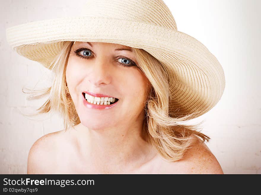 Beautiful middle aged woman wearing a sun hat and smiling. Beautiful middle aged woman wearing a sun hat and smiling.