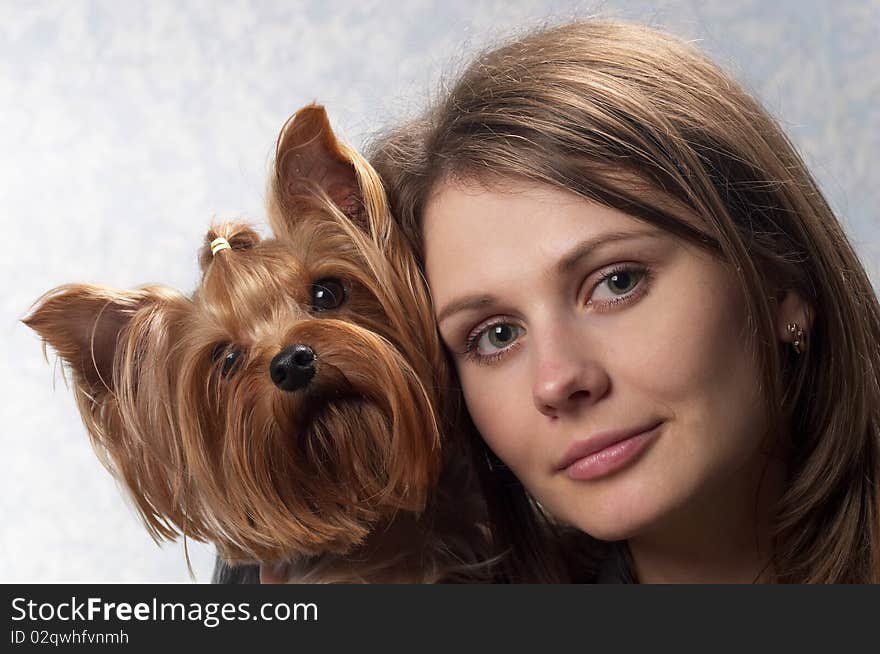 Young woman with her Yorkshire terrier portrait over light defocused background. Young woman with her Yorkshire terrier portrait over light defocused background