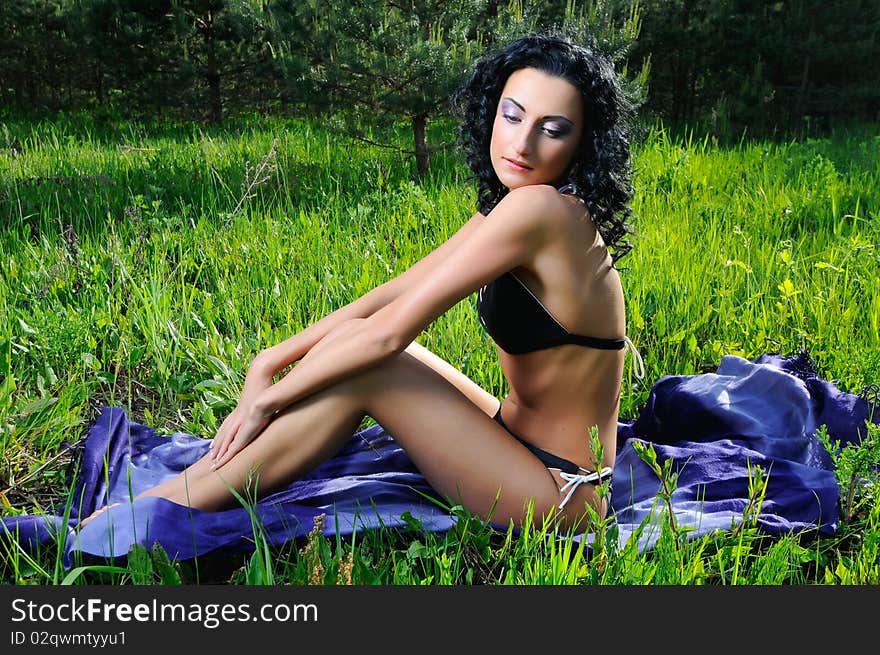 Young beautiful woman wearing black bikini sunbathing