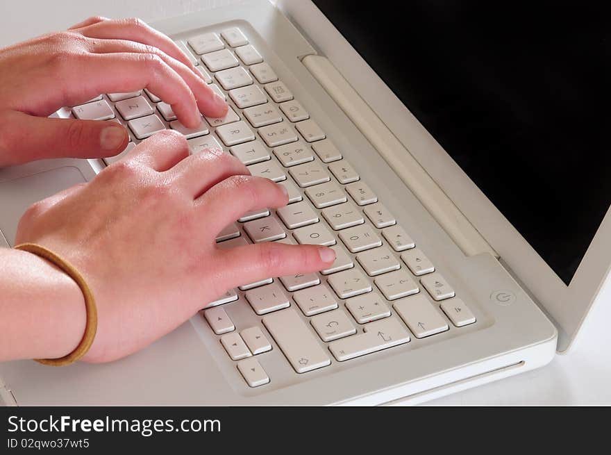 Typing on a white personal computer. Typing on a white personal computer.