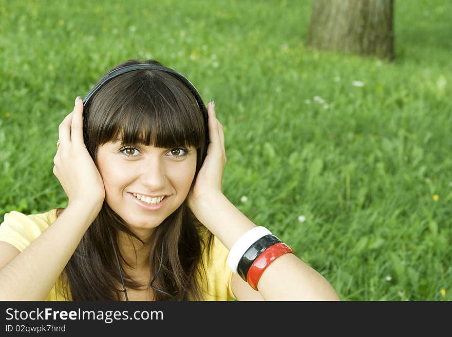 Smiling young woman listening to music at park