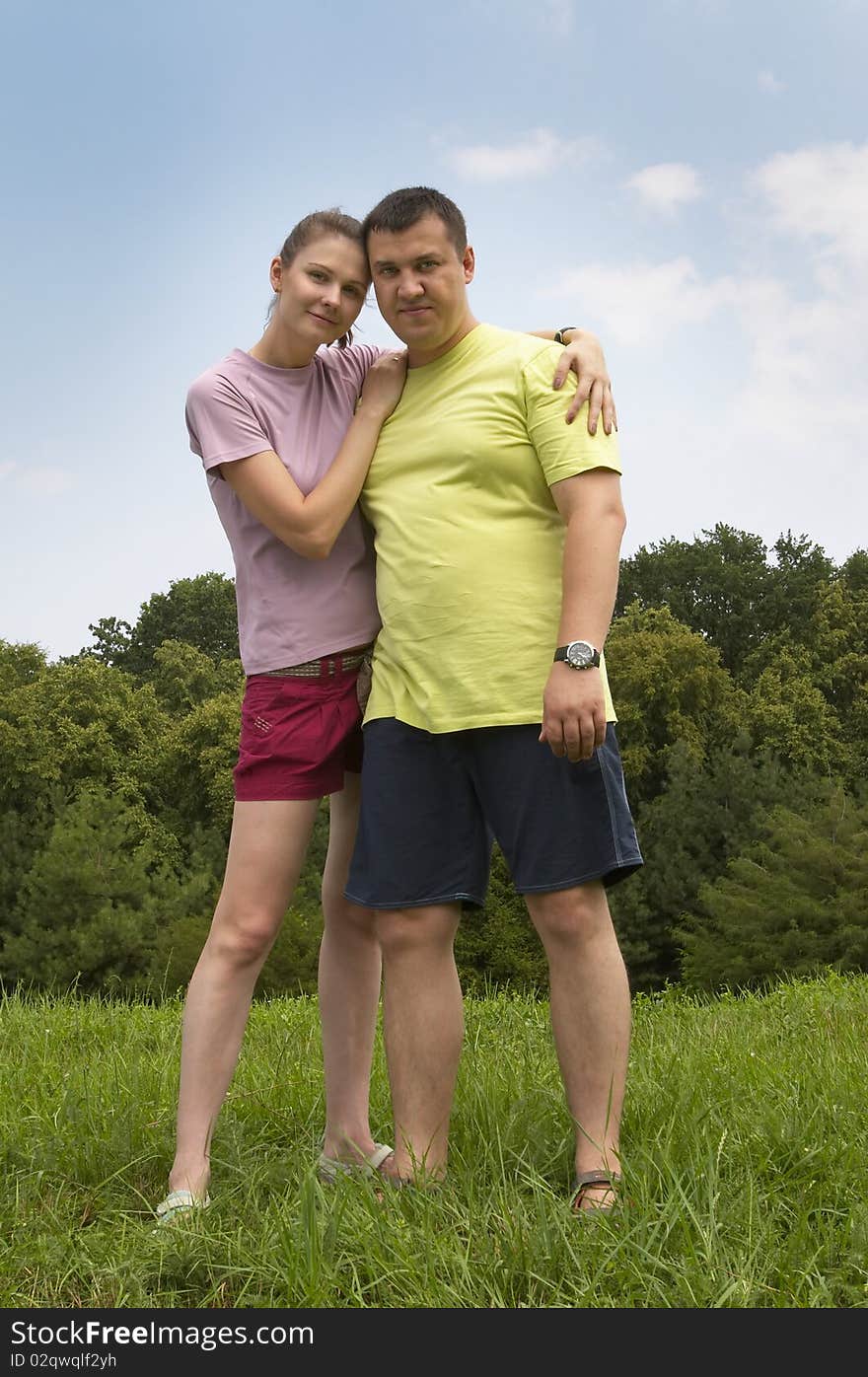 Young couple in the park over defocused background