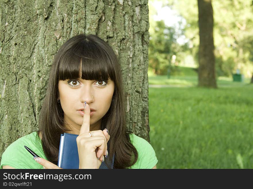 Young beautiful woman in a park with a notebook. Young beautiful woman in a park with a notebook.