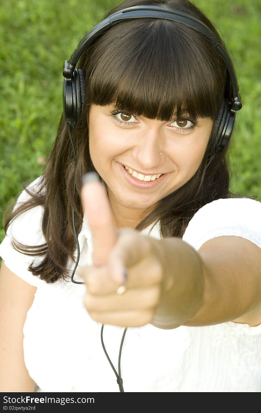 Smiling young woman listening to music at park