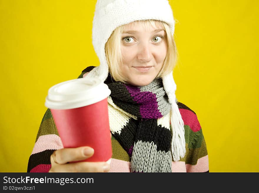 Young woman in a warm sweater, scarf and hat holding a paper cup of coffee. Winter. Young woman in a warm sweater, scarf and hat holding a paper cup of coffee. Winter