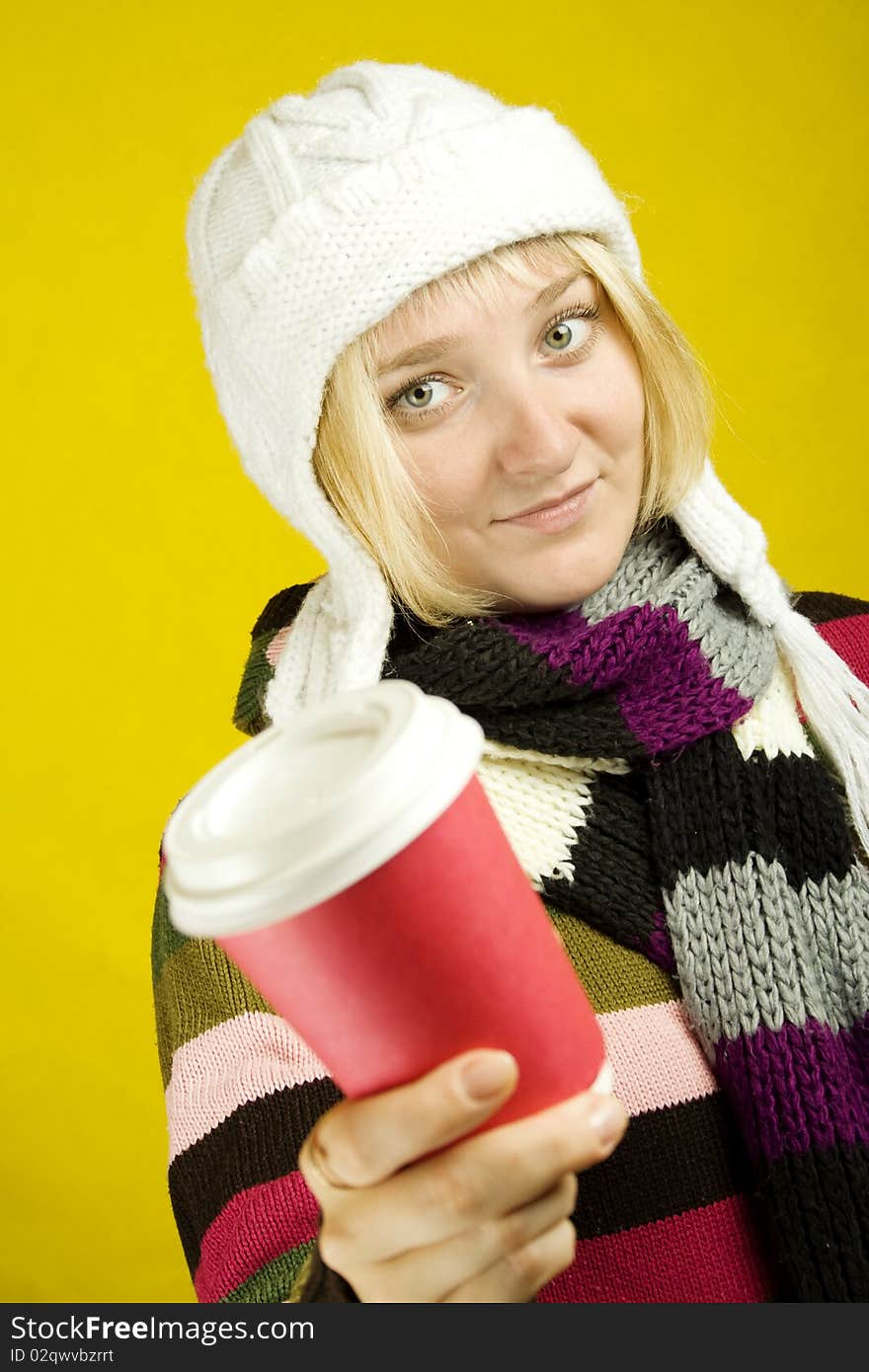 Young woman in a warm sweater, scarf and hat holding a paper cup of coffee. Winter. Young woman in a warm sweater, scarf and hat holding a paper cup of coffee. Winter