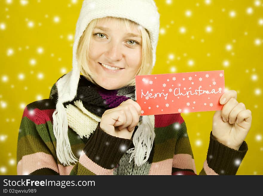 Young woman holds the card with the text Merry Christmas