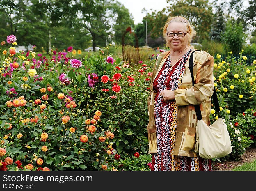 Smiling older lady in blooming garden. Smiling older lady in blooming garden