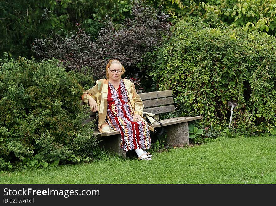 Older lady relaxing in green garden. Older lady relaxing in green garden