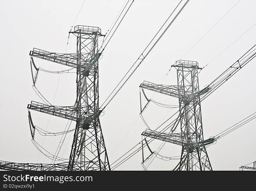 Power line pylons in the gray smog