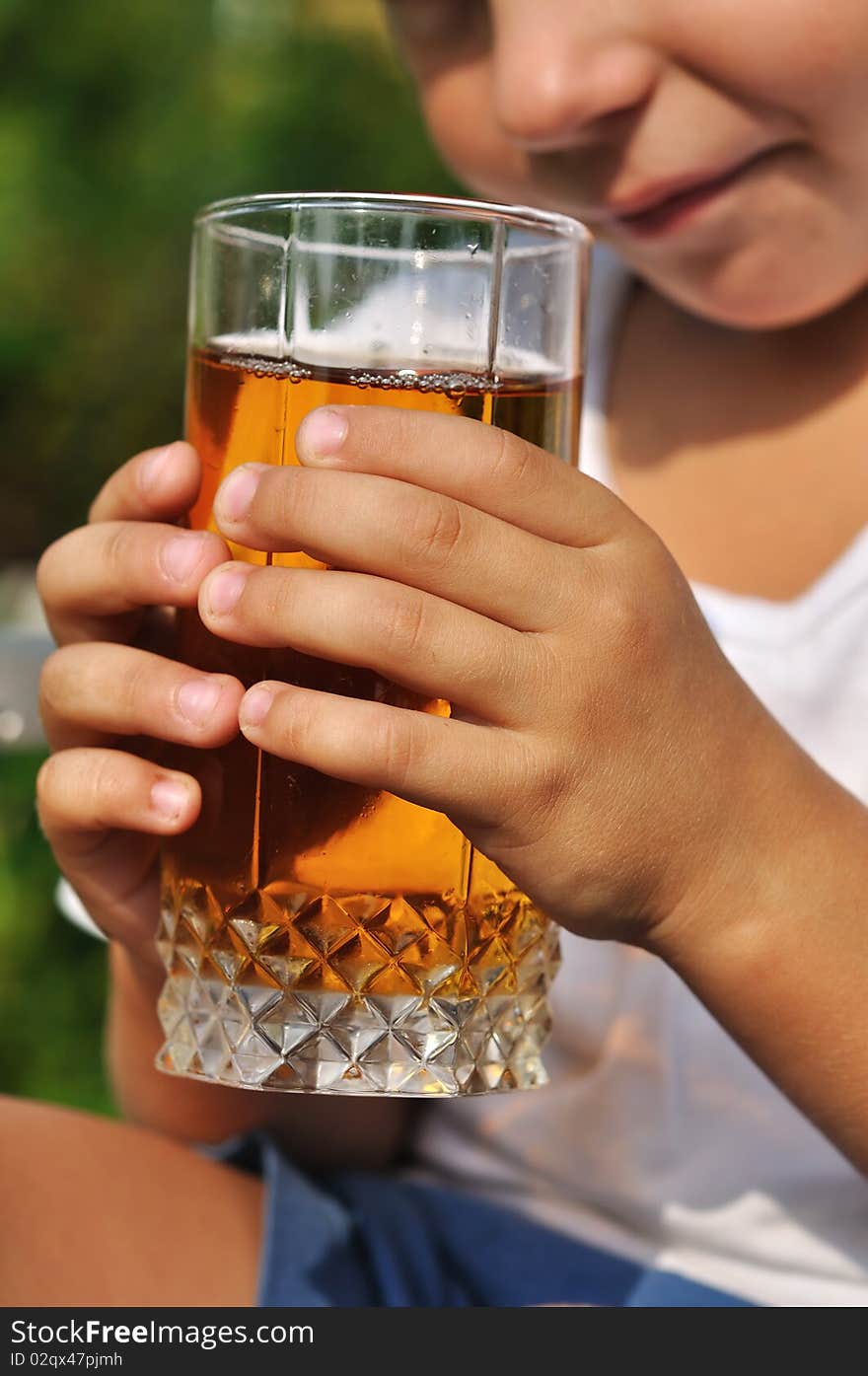 Child hands holding glass of apple juice. Child hands holding glass of apple juice