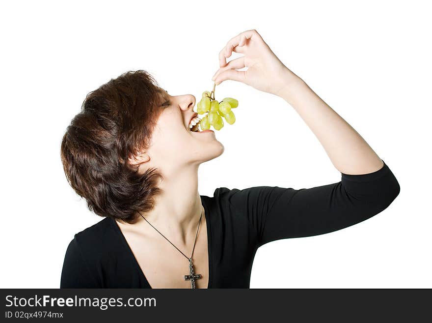 The girl eats green grapes, holding it in a hand. The girl eats green grapes, holding it in a hand