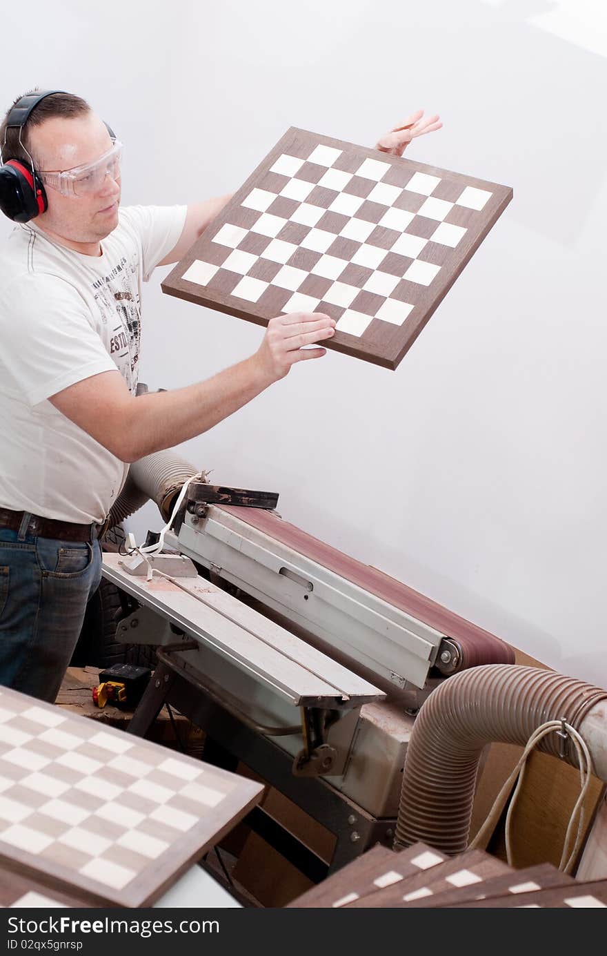 Carpenter working on an electric buzz saw cutting some boards