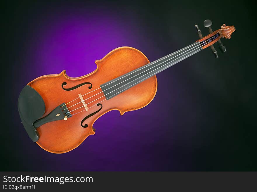 An antique violin viola isolated against a spotlight purple background. An antique violin viola isolated against a spotlight purple background.