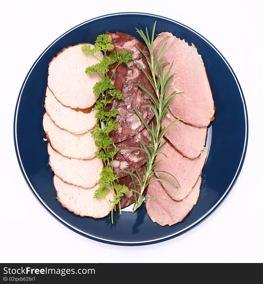 Plate of assorted cold cuts (ham, sirloin, headcheese) decorated with rosemary and parsley