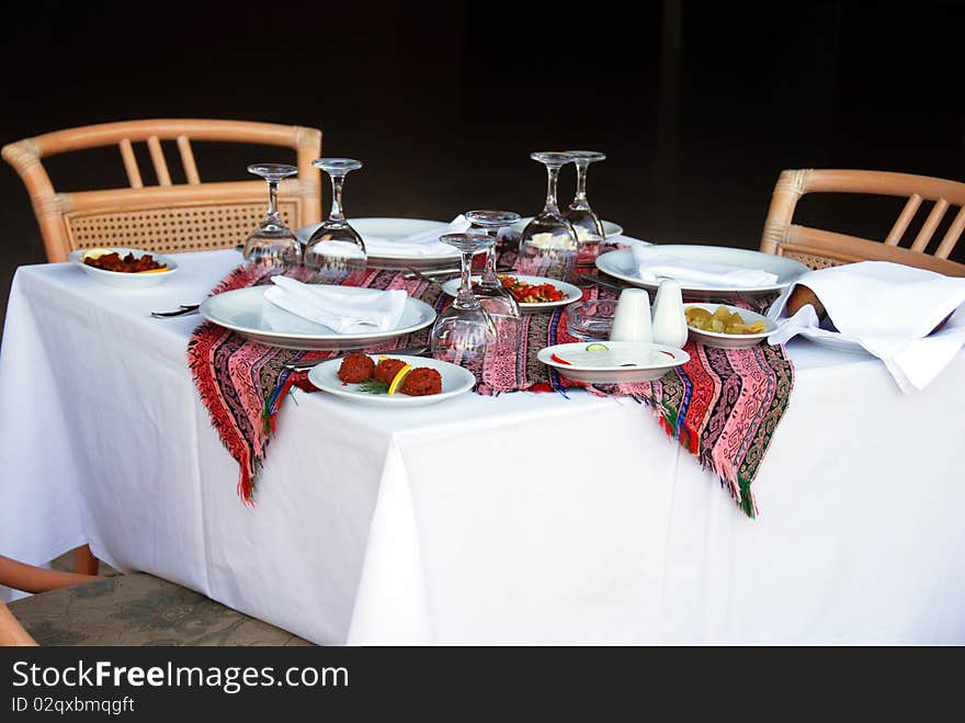 Outdoor table with served plate and wine glasses. Outdoor table with served plate and wine glasses