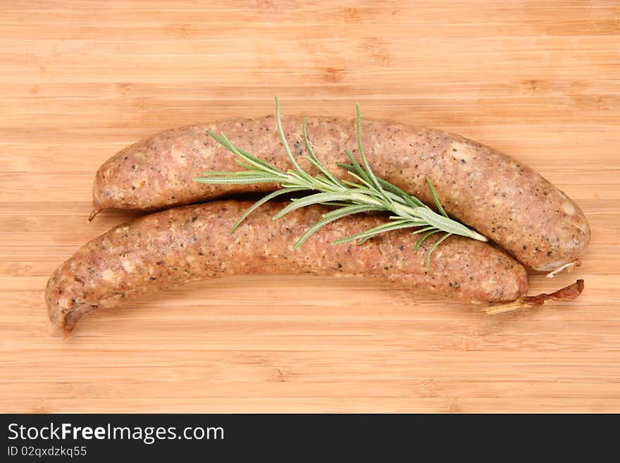 Traditional sausages on a wooden background decorated with rosemary twig