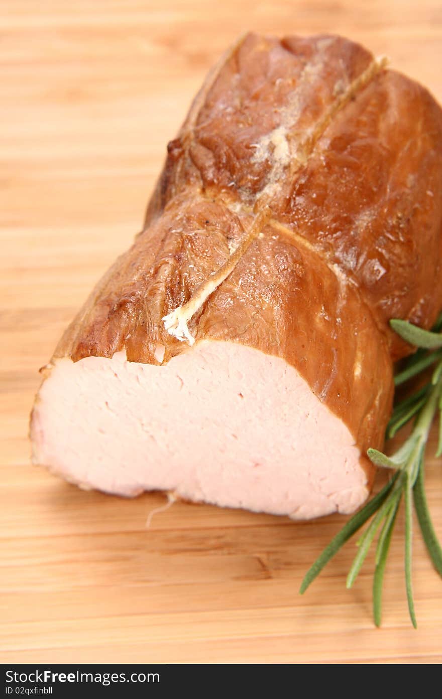 Piece of sirloin decorated with rosemary on a wooden background