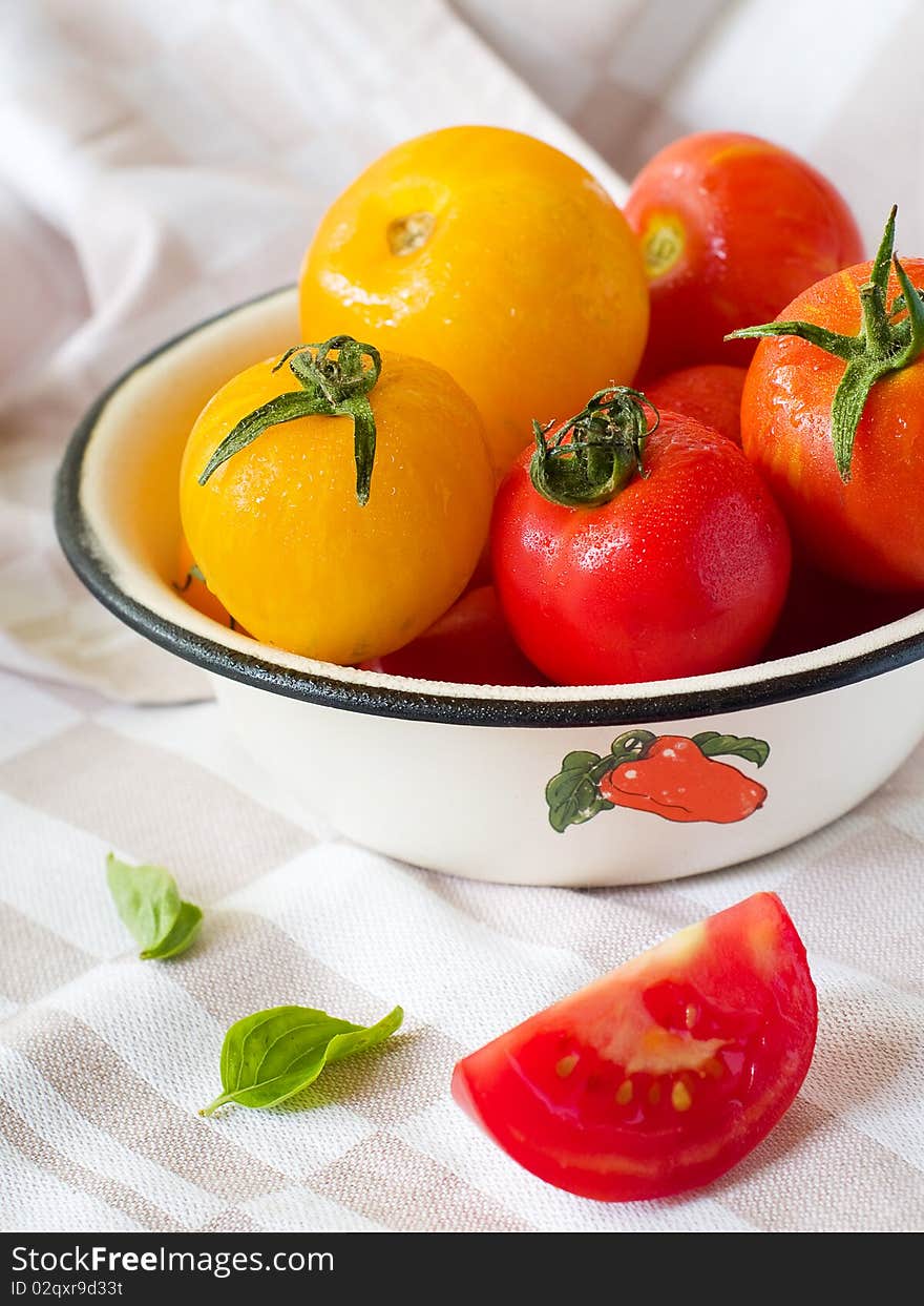 Colorful  tomatoes in bowl on kitchen table