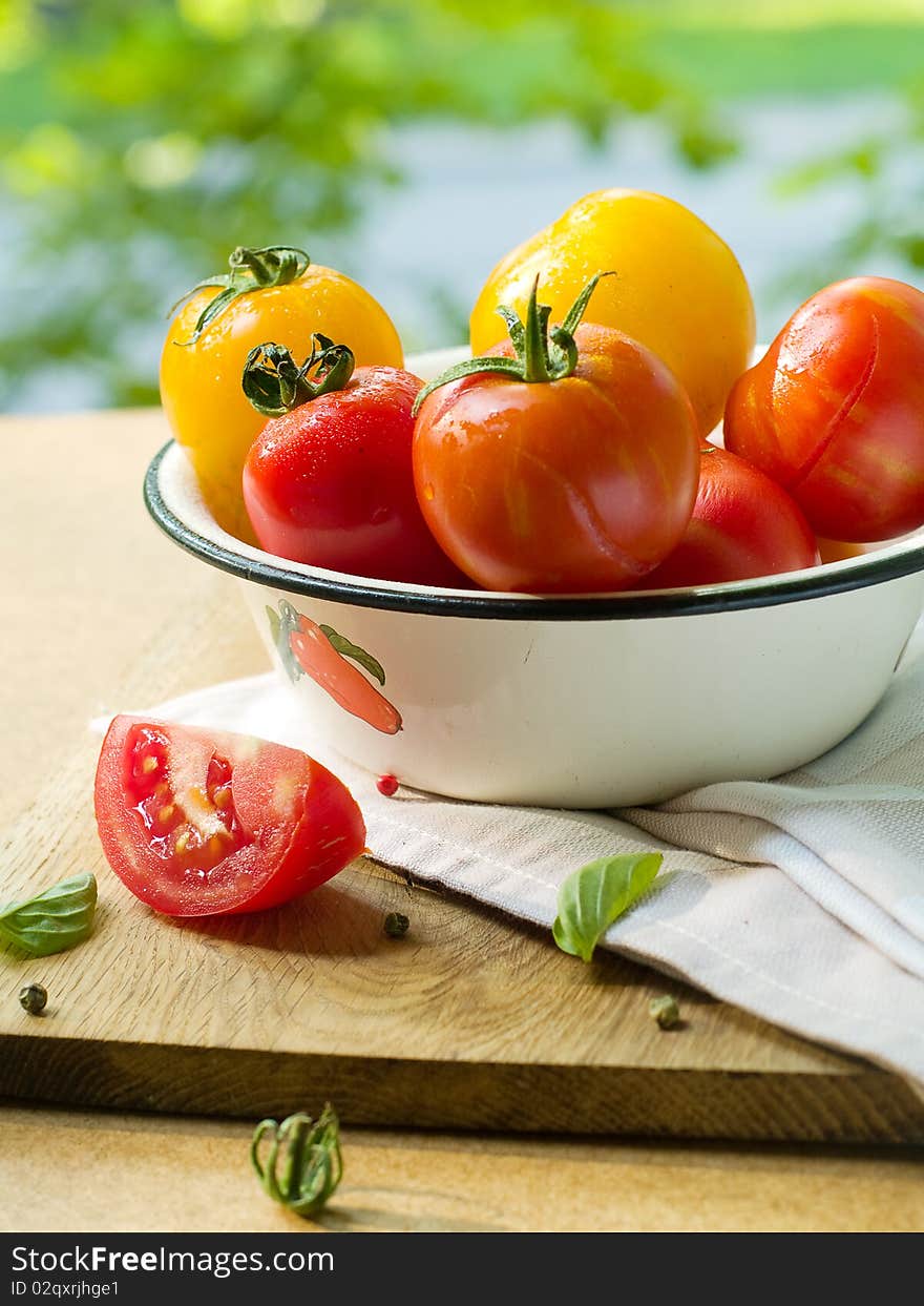 Colorful  tomatoes in bowl on kitchen table