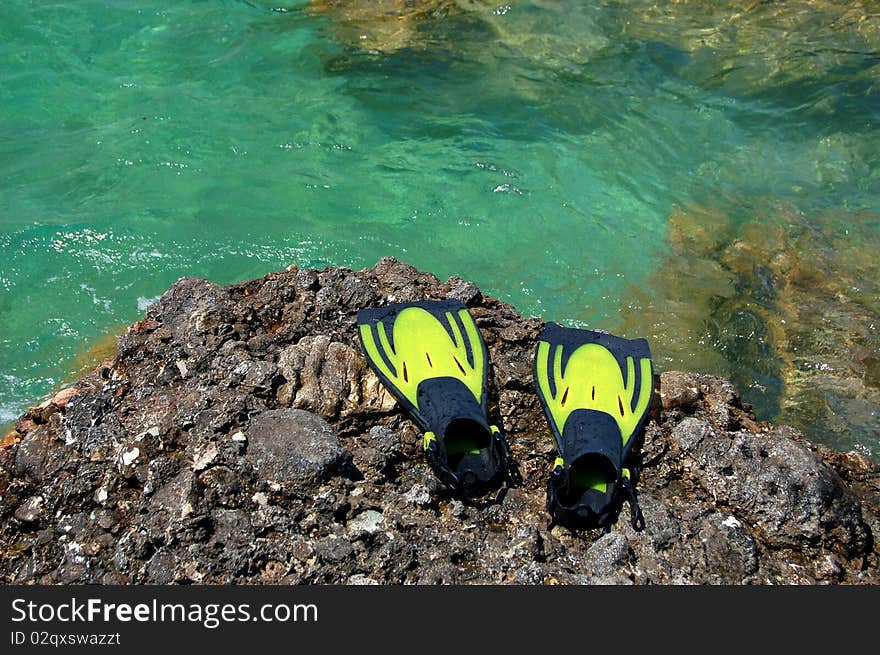 A pair of yellow fins on a rocky Montenegrin beach. A pair of yellow fins on a rocky Montenegrin beach