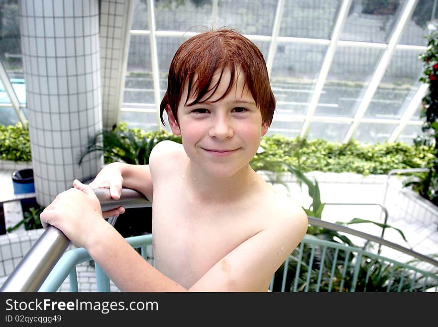 Young boy with red hair gets out of the pool