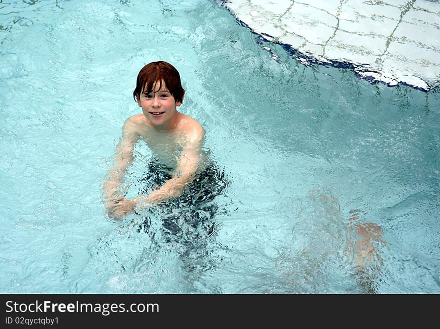 Young boy has fun in the public indoor pool