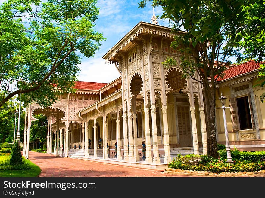 The Abhisek Dusit Throne Hall, a single story ornate building with beautifully carved floral motifs on panels adorning the gables and eaves.