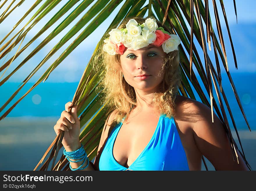 Woman in flower diadem on the beach