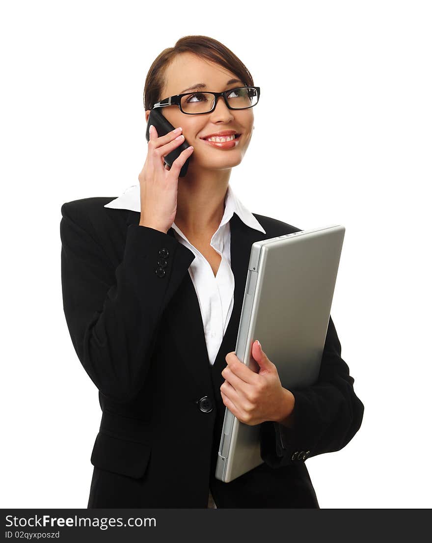 Young successful career woman holds her laptop and talks on her mobile phone. Young successful career woman holds her laptop and talks on her mobile phone