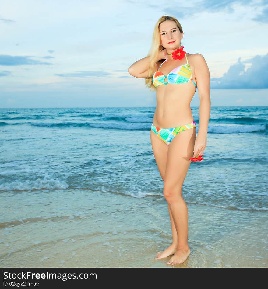 Beautiful young woman with flower at the beach. Beautiful young woman with flower at the beach