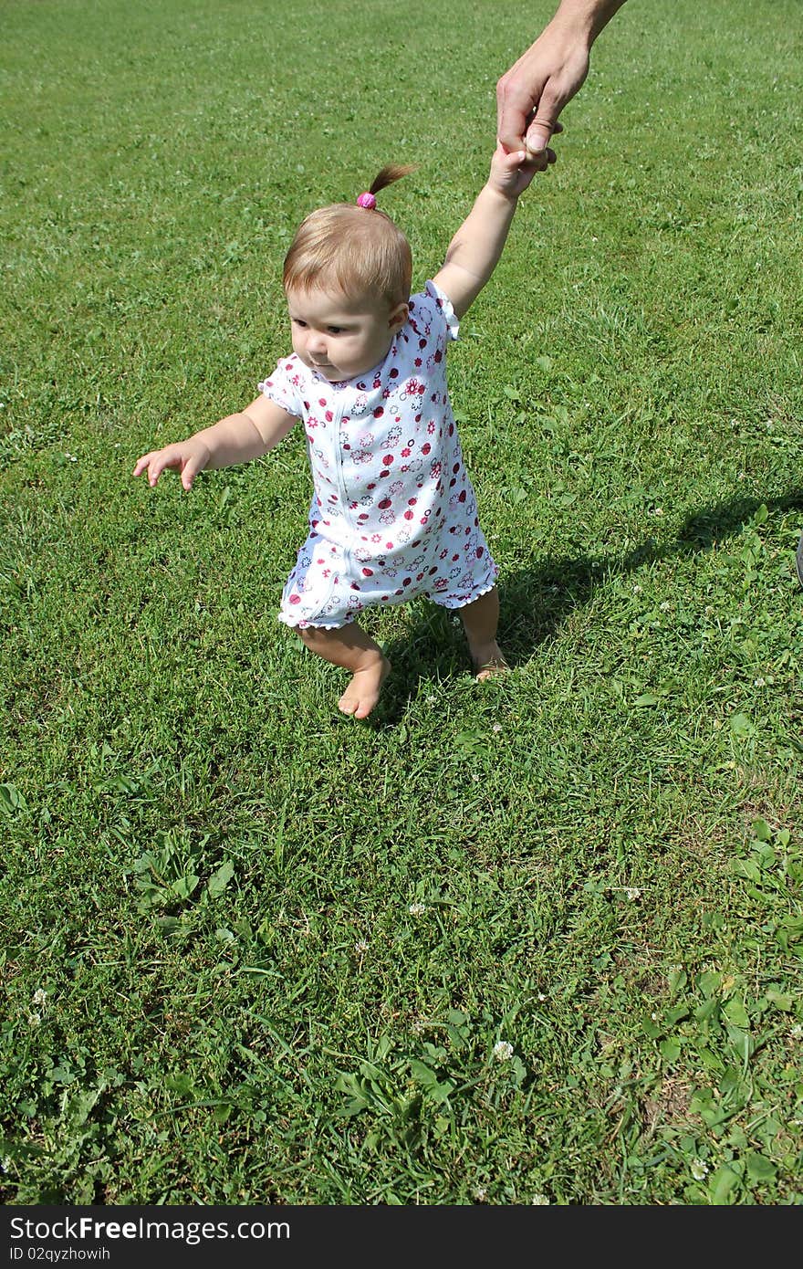 First steps the child on the grass