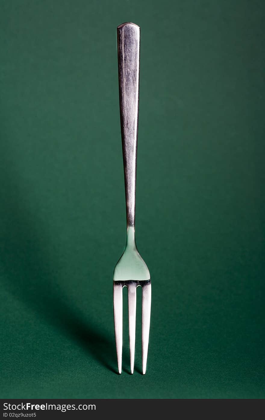 Metal fork isolated on green