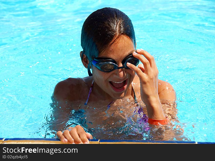 Happy teen girl in blue swimming pool portrait. Happy teen girl in blue swimming pool portrait