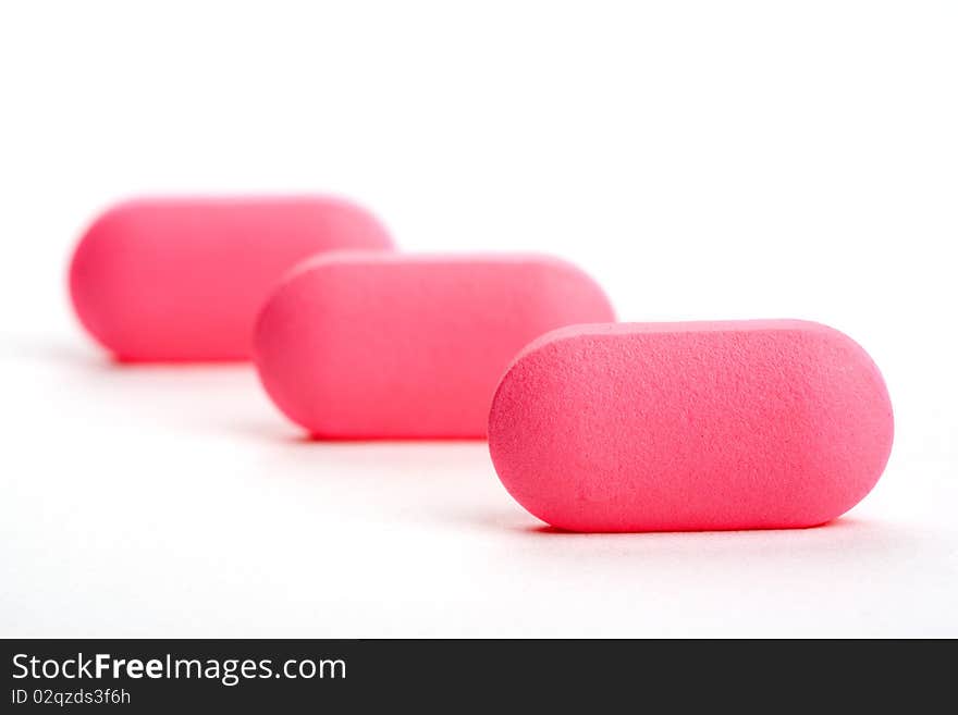 Extreme Close-up Of Pink Pills Isolated On White