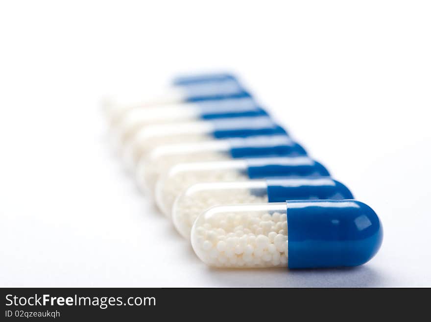 Close-up of blue medical capsules isolated on white background