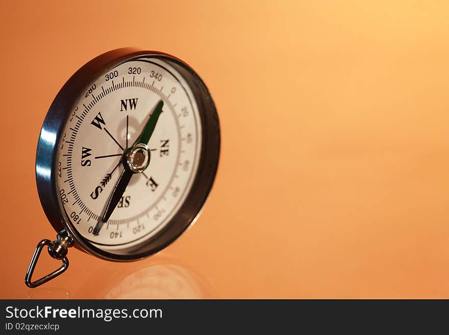 Closeup of compass standing on red background with copy space