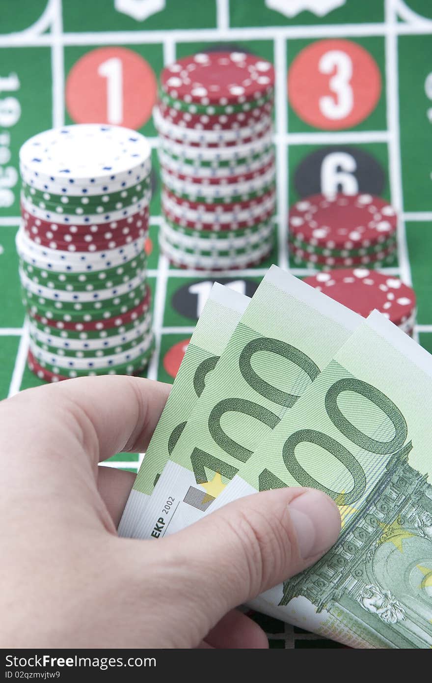 Stack of multicolor gambling chips on casino table, male hand