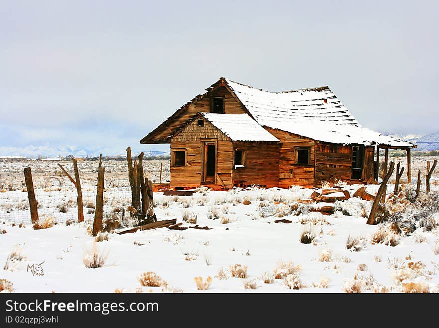 Abandoned homestead on prairie in winter snows