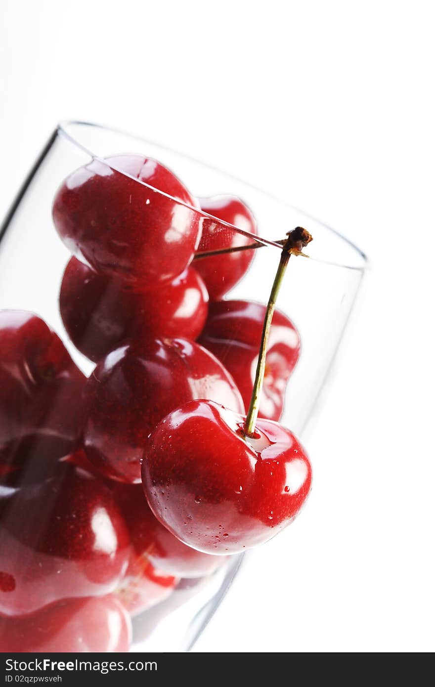 Cherries in a glass on white background