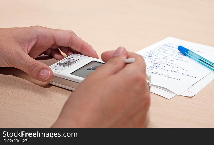 White woman entering data into a white pda. White woman entering data into a white pda