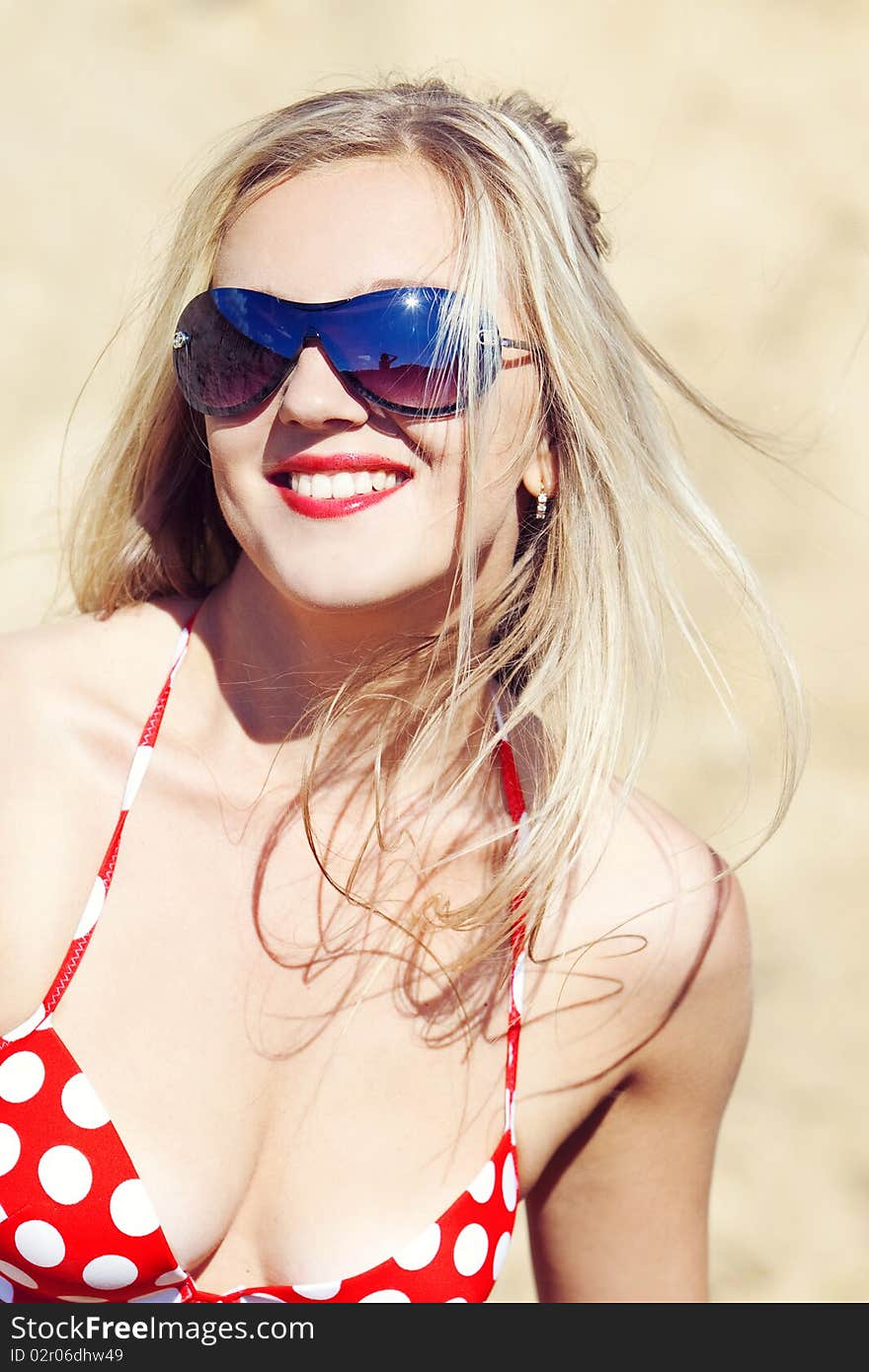 Young beautiful girl in a bathing suit on sand