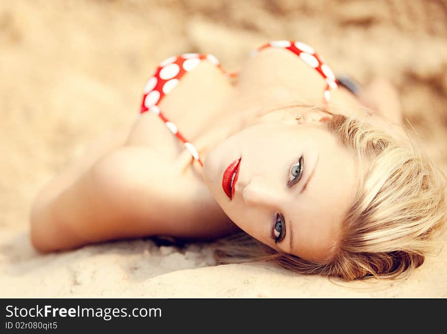 Young beautiful girl in a bathing suit on sand