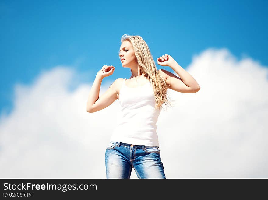 Young beautiful girl against the dark blue sky