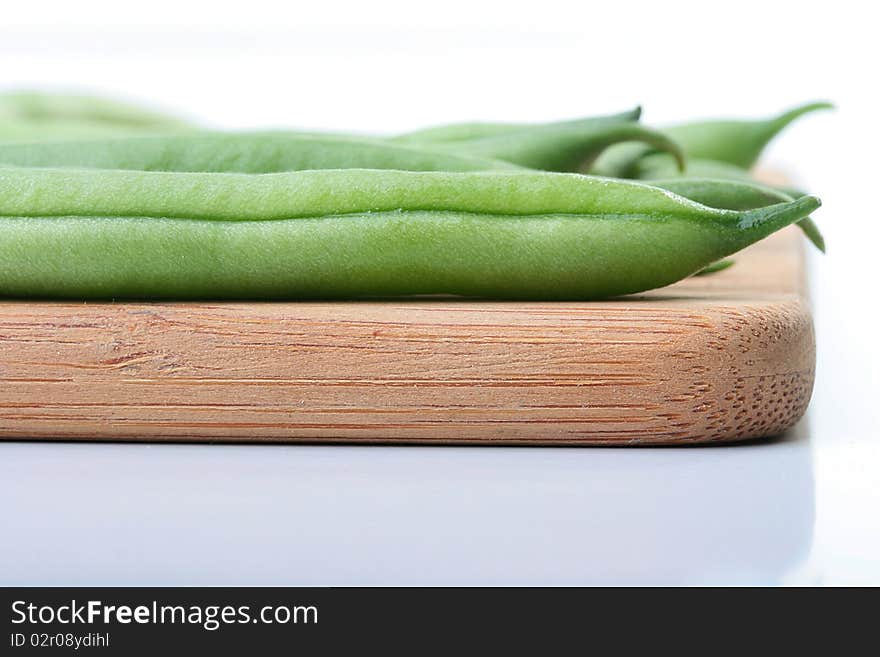 Vegetable kidney bean beans against on a kitchen board.