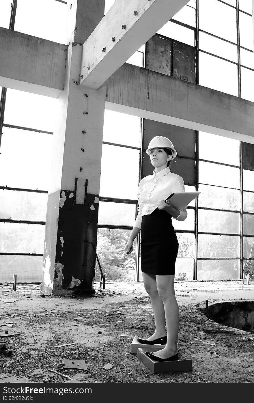 Young real estate sales person starting planning working in demolished constructions. Young real estate sales person starting planning working in demolished constructions