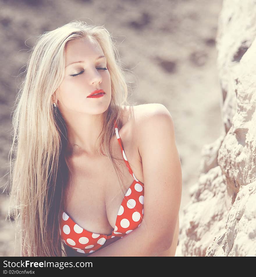 Young beautiful girl in a bathing suit on sand