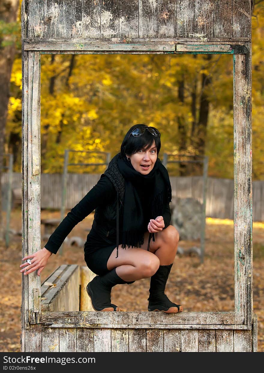 Outdoor portrait of young woman in dirty wooden frame. Outdoor portrait of young woman in dirty wooden frame