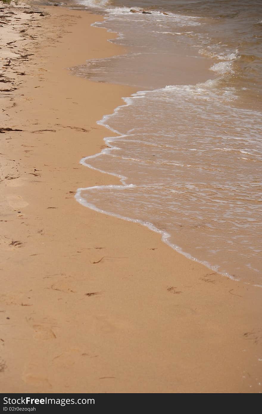 Waves hitting a sandy beach. Waves hitting a sandy beach