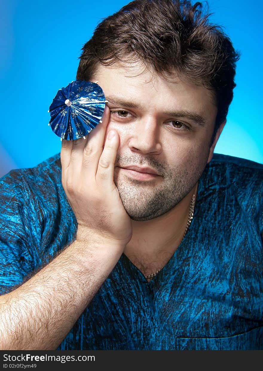 Portrait of tranquil man with cocktail umbrella. Portrait of tranquil man with cocktail umbrella